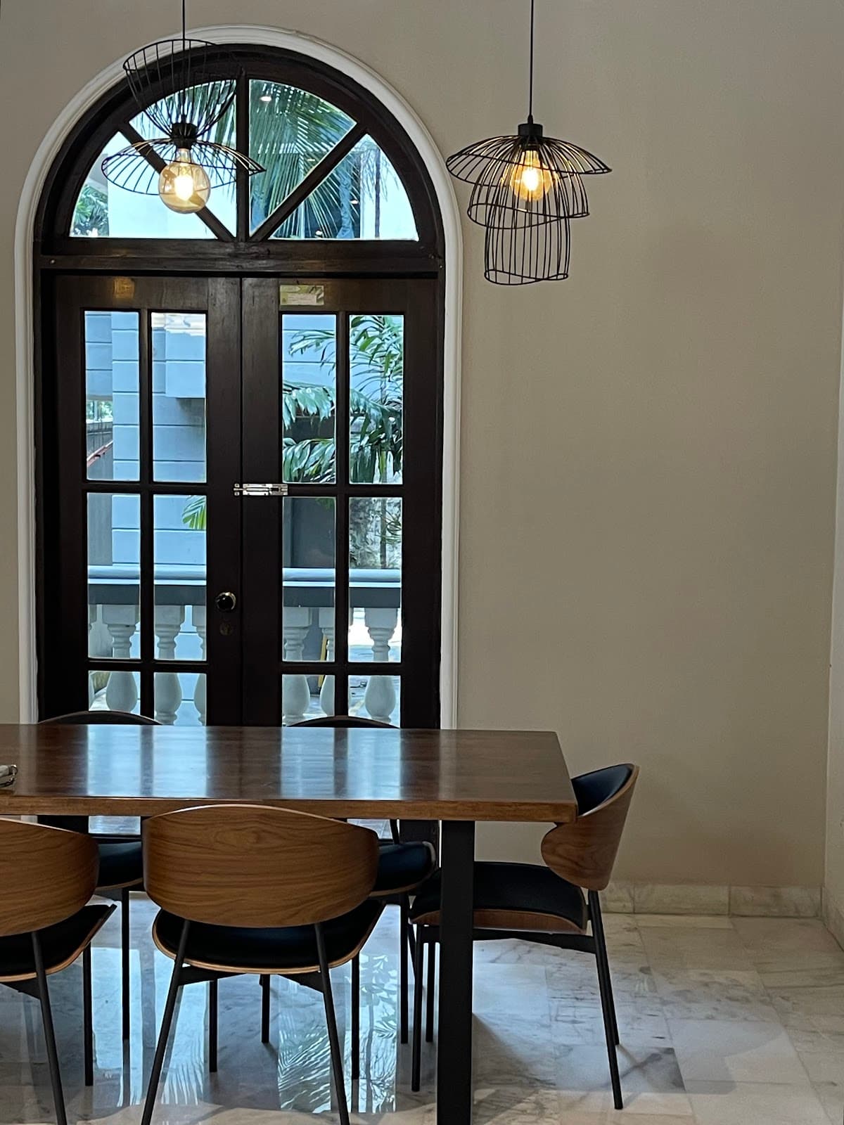 A quiet table beside the arched black-framed doors